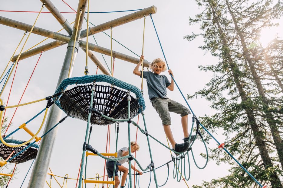 Junge klettert auf Kletterspielplatz