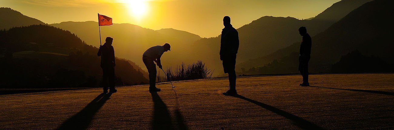Golfspieler am Golfplatz bei Sonnenuntergang