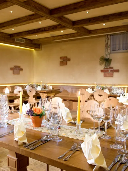 Elegantes rustikales Restaurant mit gedeckten Tischen, Kerzen und gefalteten Servietten