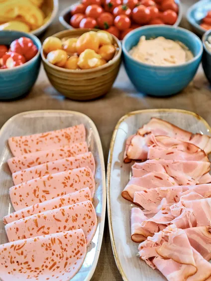 Aufschnitt und Delikatessfleisch mit Gemüse, Soßen und Antipasti auf einem Frühstücksbuffet