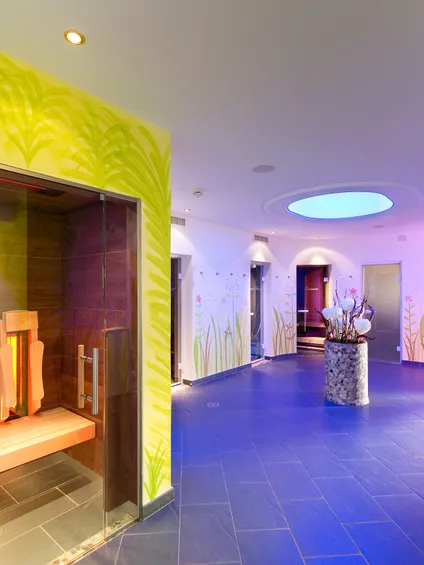 Modern spa wellness area with infrared sauna, floral wall decor and ambient lighting
