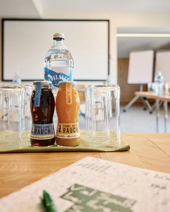 Konferenzraum mit Saftflaschen, Wasser und Gläsern auf einem Tisch