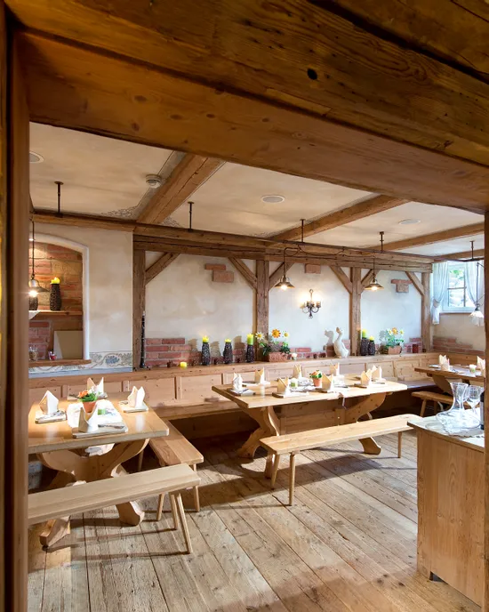 Rustikales Holzrestaurant mit gedeckten Tischen und warmer Ambientebeleuchtung