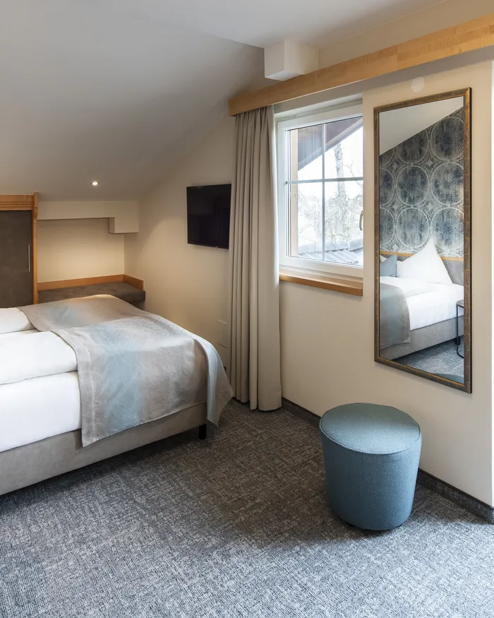 Camera d'hotel moderna con letto matrimoniale, accesso al balcone e arredamento elegante