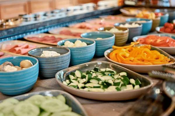 Frisches Gemüse- und Aufschnittbuffet mit Gurken, Paprika, Zucchini und verschiedenen Dips