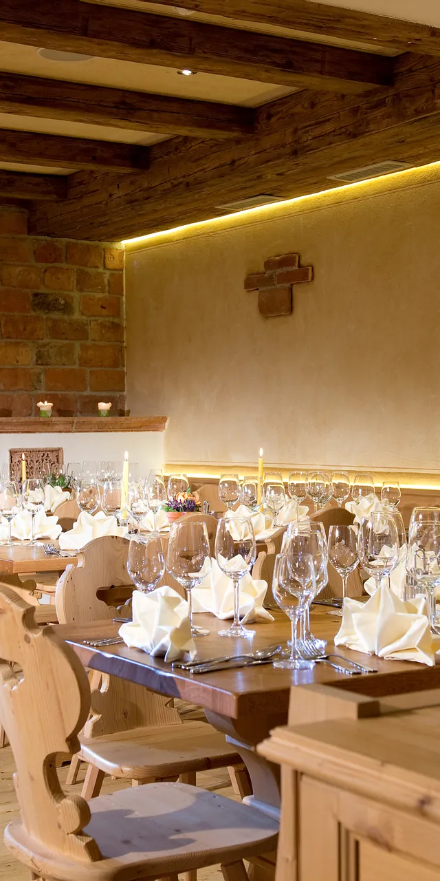Rustikales Restaurant mit gedeckten Holztischen, Weingläsern und Kerzen