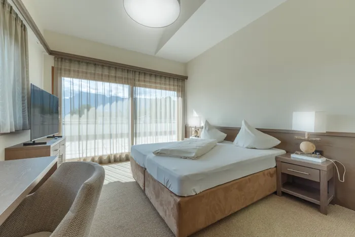 Modern hotel room with large windows and mountain view