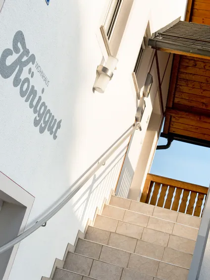 Außentreppe führt zum Holzbalkon beim Wohnhaus Königgut