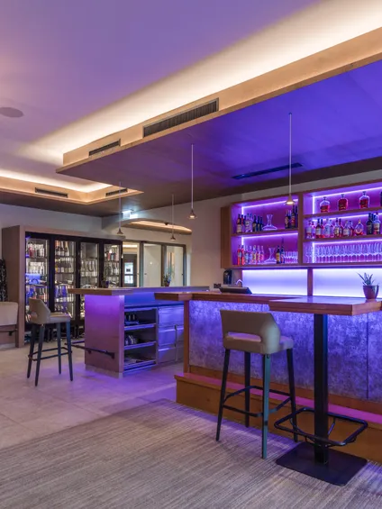 Moderne Bar mit stilvoller Beleuchtung und gut bestückten Regalen