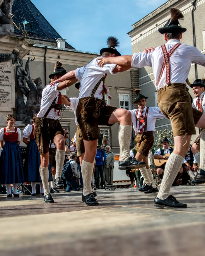 Männer in Tracht tanzen bayerischen Volkstanz bei einem Kulturfest im Freien