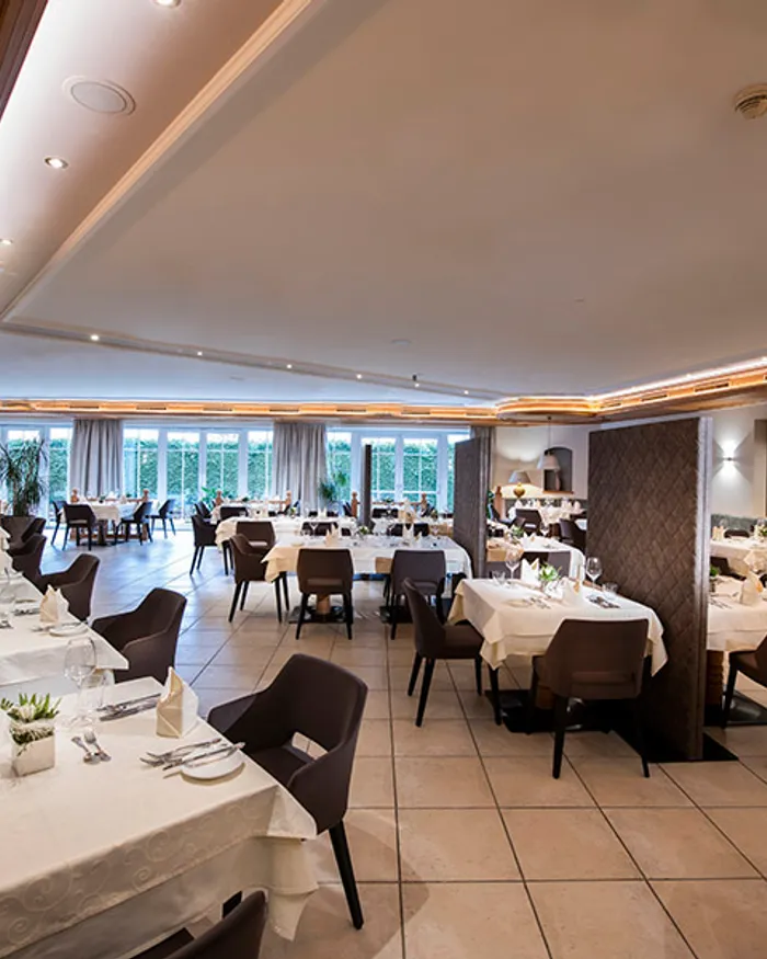 Elegantes Restaurant mit gedeckten Tischen, moderner Einrichtung und natürlichem Licht