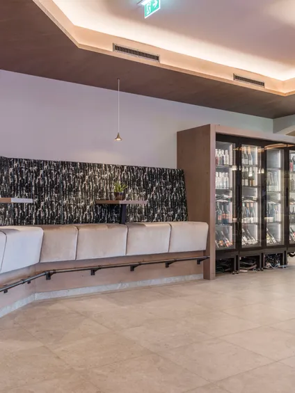 Moderner Café-Innenraum mit gepolsterten Sitzgelegenheiten, Wanddekoration und Kühlvitrine