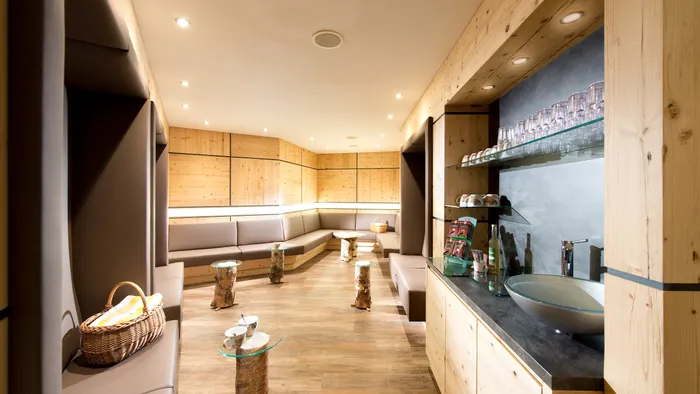 Modern wellness lounge with wooden walls, cozy seating and refreshment area