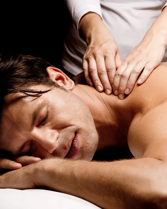 Mann genießt eine entspannende Schultermassage im Spa