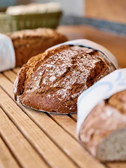 Frisch gebackene Brotleibe auf Holzrost in einer Bäckerei