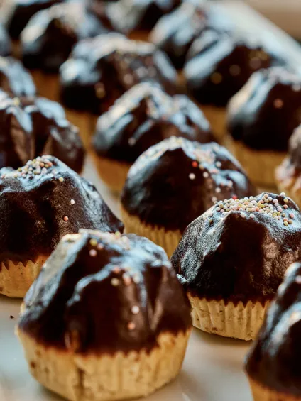 Cupcake con glassa al cioccolato e zuccherini su un vassoio bianco