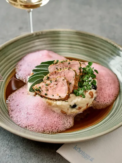 Gourmet-Schweinefilet auf Risotto mit rotem Schaum und Kräutern, serviert mit Weißwein