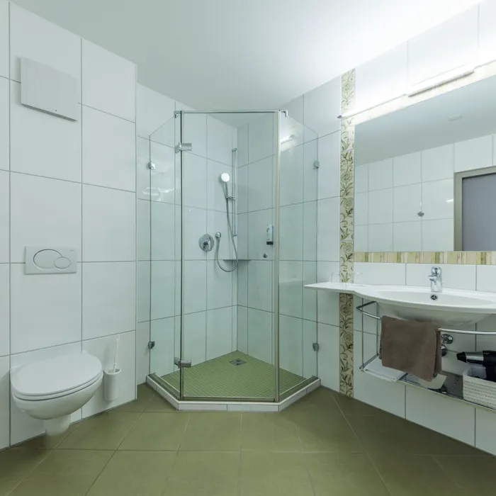 Modernes Badezimmer mit Duschkabine, weißen Fliesen und großem Spiegel