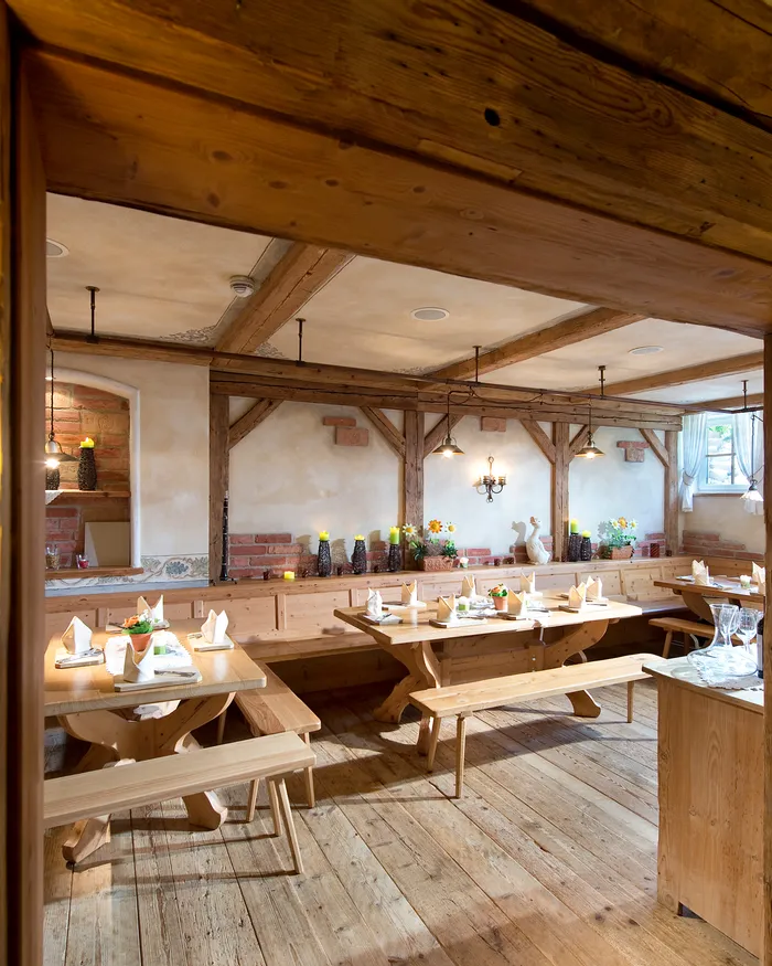 Rustikales Holzrestaurant mit gedeckten Tischen und warmer Ambientebeleuchtung