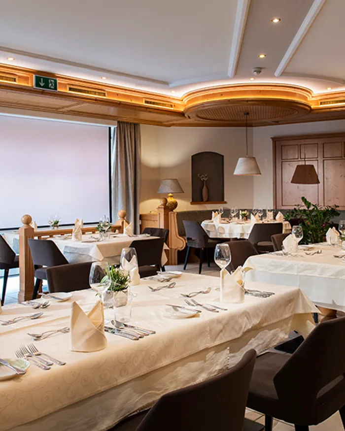 Elegantes Restaurant mit gedeckten Tischen, gefalteten Servietten und warmer Beleuchtung