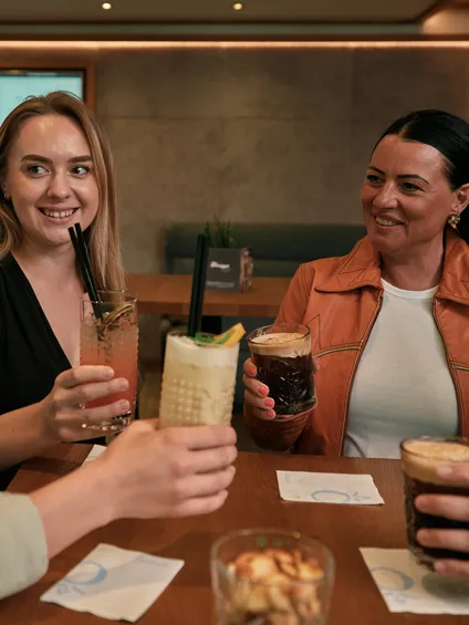 Gruppe von Frauen genießt Cocktails und Eiskaffee am Restauranttisch