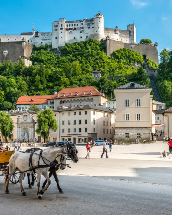 Pferdekutsche am Kapitelplatz in Salzburg mit der Festung Hohensalzburg im Hintergrund