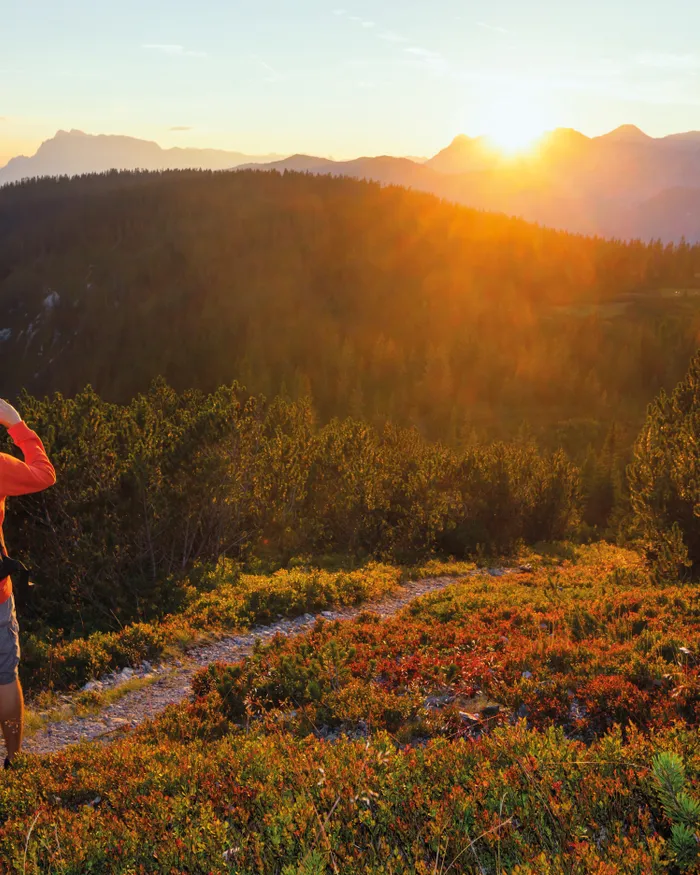 Wanderer mit Rucksäcken genießen den Sonnenuntergang in alpiner Berglandschaft