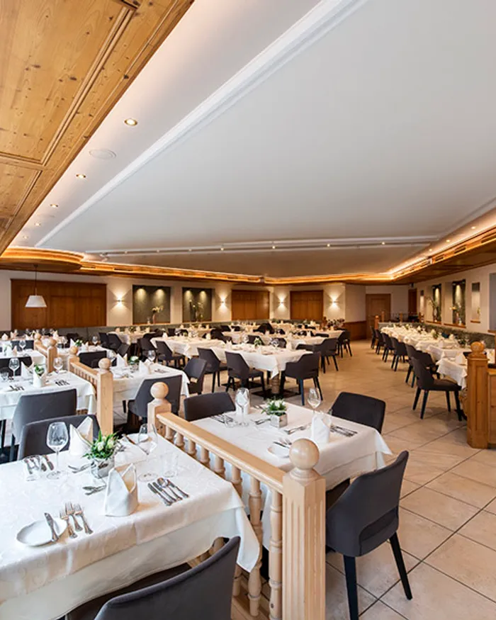 Elegantes Hotelrestaurant mit gedeckten Tischen, Holzakzenten und natürlichem Licht