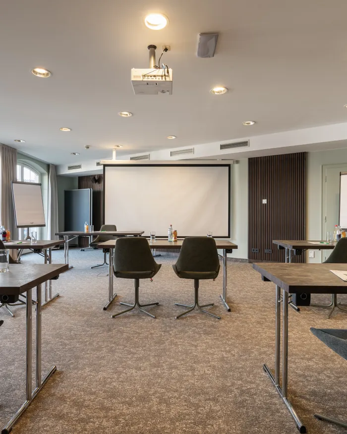 Modern conference room with projector, large screen, chairs and tables set for meeting