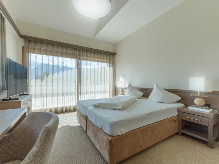 Modernes Hotelzimmer mit großen Fenstern und Bergblick