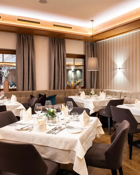 Elegantes Restaurant-Esszimmer mit gedeckten Tischen, Holzboden und moderner Dekoration