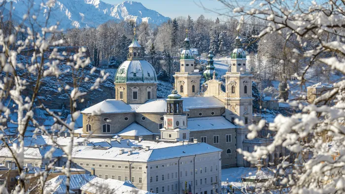 Verschneener Salzburger Dom mit Alpen im Hintergrund