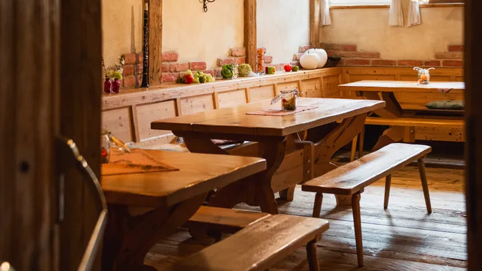 Rustikales Holzspeisezimmer mit Bänken, Bauernhaus-Dekor und warmem natürlichem Licht