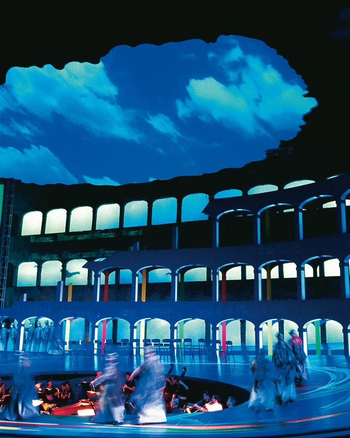 Palcoscenico teatrale con scenografia moderna a forma di Colosseo e proiezione di cielo blu