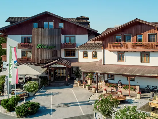 Hotel alpino tradizionale Königgut con balconi in legno e bandiere austriache in estate