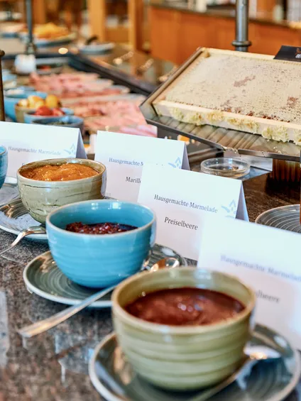 Hotel-Frühstücksbuffet mit hausgemachter Marmelade, Honigwabe und frischen Zutaten