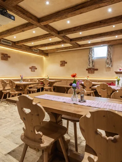 Interno di ristorante rustico accogliente con mobili in legno, decorazioni floreali e illuminazione soffusa