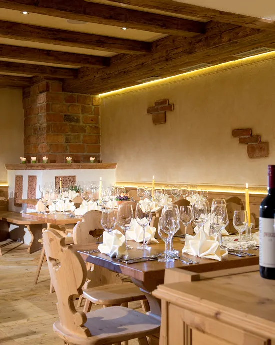 Rustikales Restaurant mit gedeckten Holztischen, Weingläsern und Kerzen