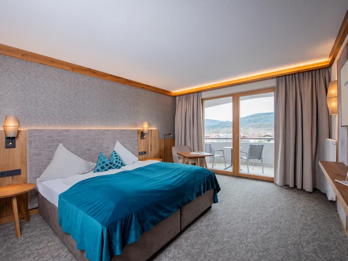 Modernes Hotelzimmer mit Doppelbett, Balkonblick und Berglandschaft
