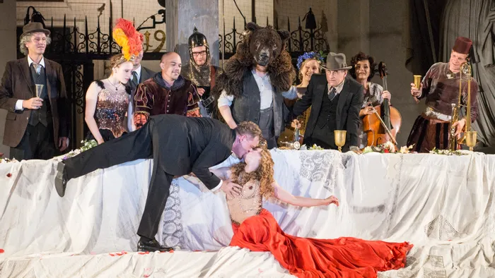 Theateraufführung mit kostümierten Schauspielern und dramatischem Kuss bei einem opulenten Bankett