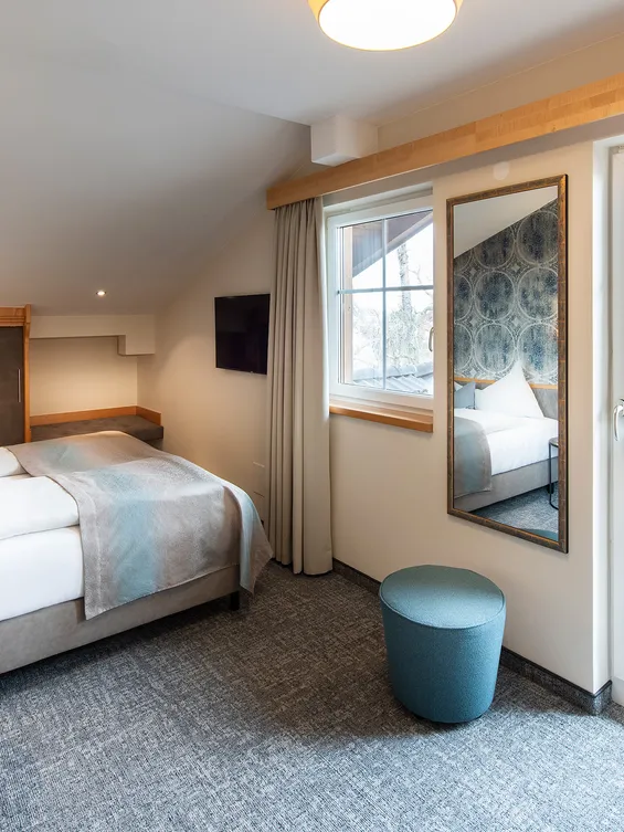 Modernes Hotelzimmer mit Doppelbett, Schreibtisch, Balkonzugang und sanfter Beleuchtung