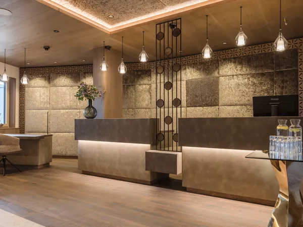 Hall di hotel moderna con banco reception elegante e luci a sospensione