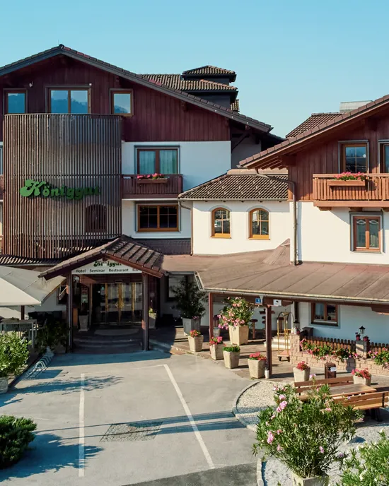 Hotel alpino tradizionale Königgut con balconi in legno e bandiere austriache in estate