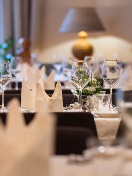 Elegante Restauranttischdekoration mit Weingläsern, gefalteten Servietten und sanfter Beleuchtung