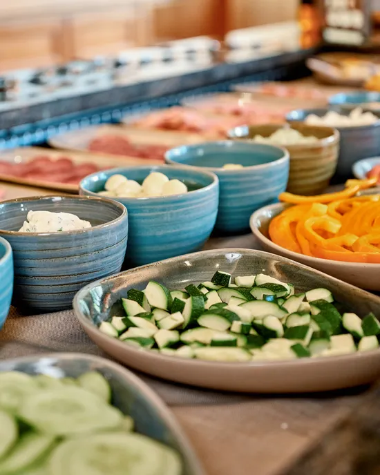 Frisches Gemüse- und Aufschnittbuffet mit Gurken, Paprika, Zucchini und verschiedenen Dips