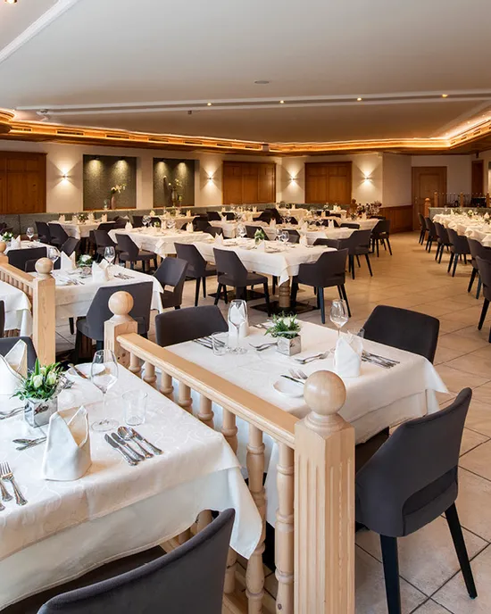 Spacious modern restaurant with elegant table settings and wooden decor elements
