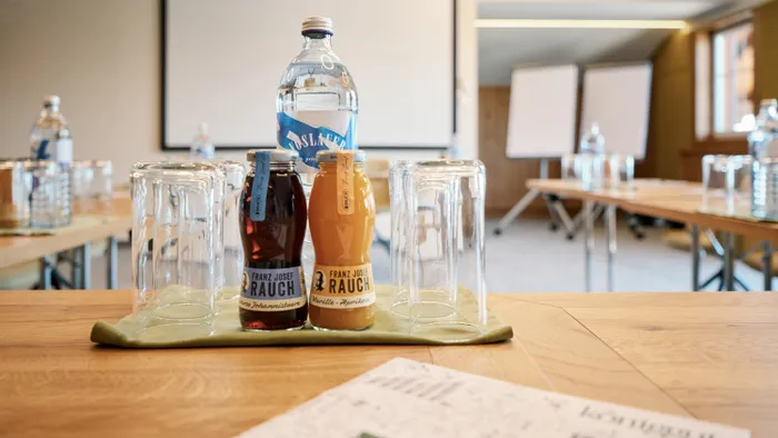 Conference room setup with juice bottles, water, and glasses on a table
