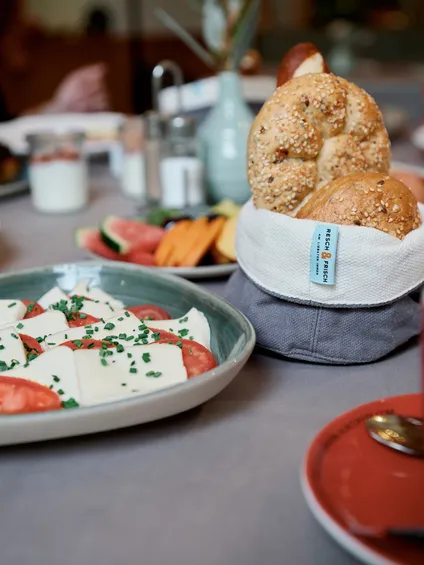 Frühstückstisch mit frischen Brötchen, Tomaten-Mozzarella-Salat und Kaffee