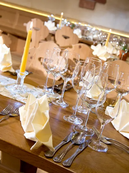 Elegant gedeckter Restauranttisch mit gefalteten Servietten, Weingläsern und brennenden Kerzen